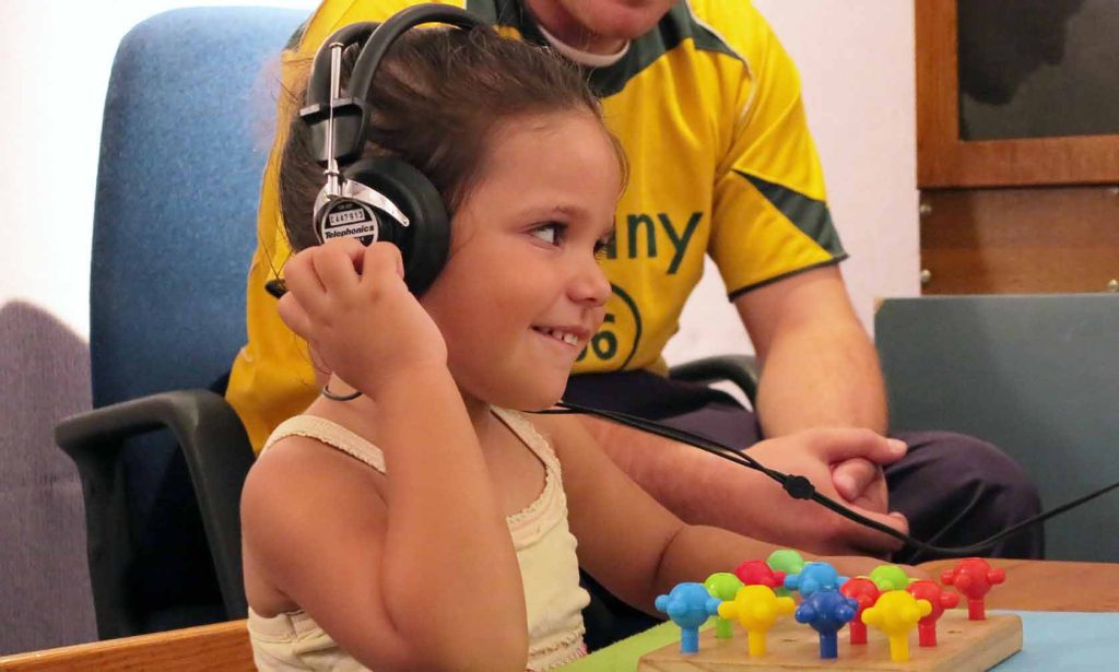 Tifel liebes headphones fuq il-widnejn u jitbissem