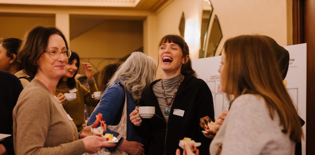 Three staff members laughing and chatting