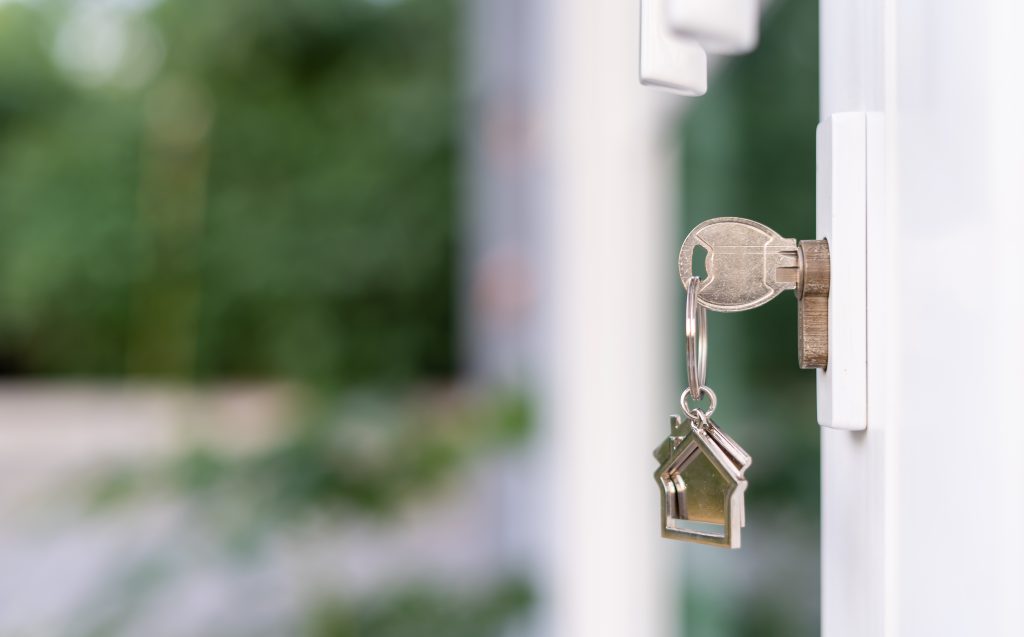 Key placed in open door lock with a house keyring on key