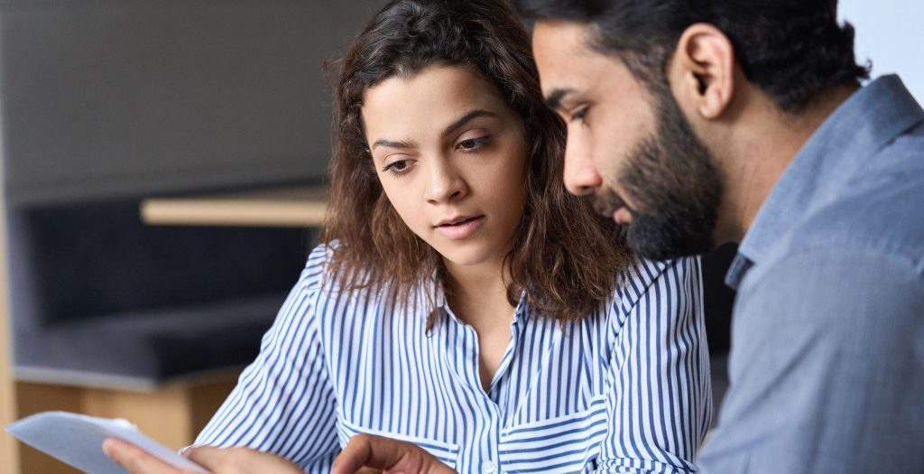 Male south asian lawyer discussing papers with a student, client.