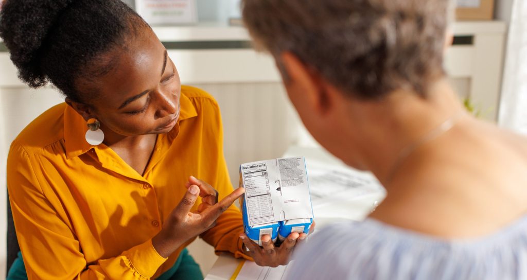 Una nutrizionista donna impara ai suoi clienti a capire e a usare l'etichetta nutrizionale