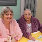 Two older women smiling at the camera